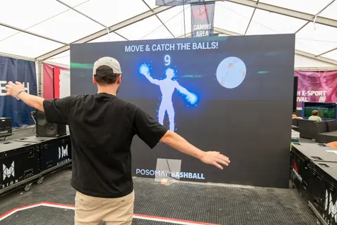 Spieler steht mit ausgebreiteten Armen vor der Bashball LED-Wand, sein Körper erscheint als Figur im Spiel